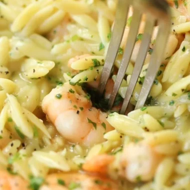Delicious Garlic Butter Prawn Orzo garnished with herbs on a plate
