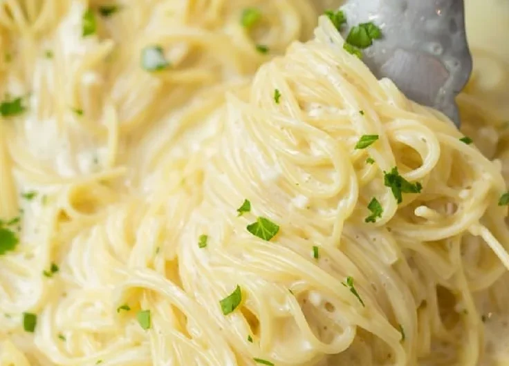Bowl of creamy garlic parmesan pasta garnished with parsley and grated cheese