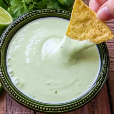 A bowl of cilantro lime cream garnished with fresh cilantro leaves