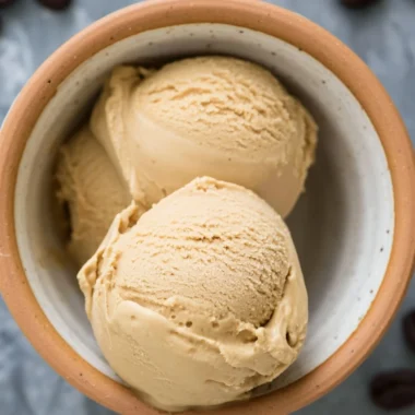 A bowl of creamy coffee ice cream topped with chocolate shavings
