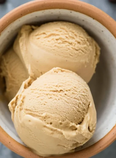 A bowl of creamy coffee ice cream topped with chocolate shavings