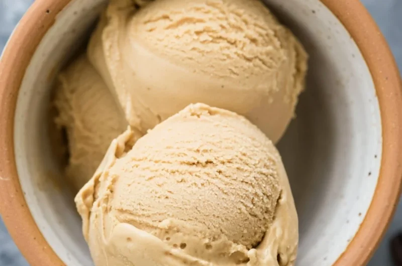 A bowl of creamy coffee ice cream topped with chocolate shavings