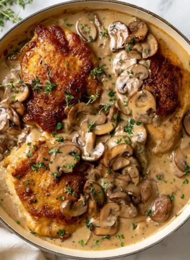 Creamy mushroom chicken served in a bowl, garnished with fresh herbs.