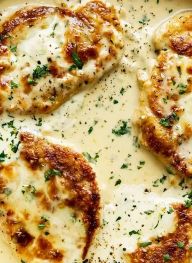Creamy ranch chicken served on a plate with fresh herbs and vegetables.