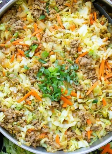 Delicious egg roll in a bowl with colorful vegetables and savory pork.