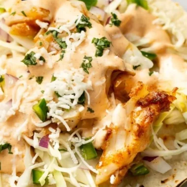 Delicious homemade fish tacos garnished with fresh herbs and lime