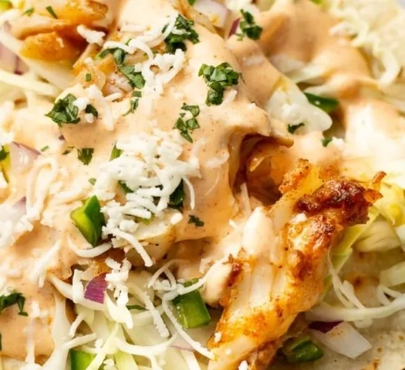 Delicious homemade fish tacos garnished with fresh herbs and lime
