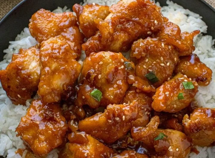 Delicious General Tso's Chicken served with vegetables and rice on a plate.