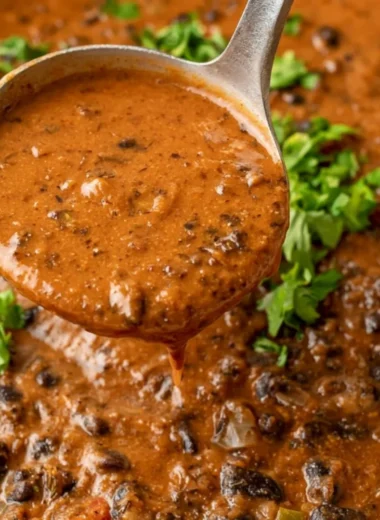 Bowl of hearty black bean soup topped with herbs and spices