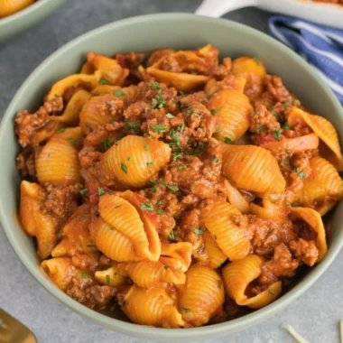High protein taco pasta dish topped with fresh ingredients and cheese