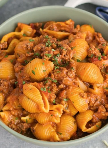 High protein taco pasta dish topped with fresh ingredients and cheese