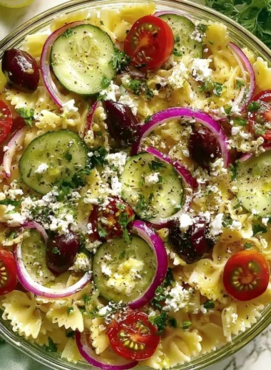 Bowl of irresistible Mediterranean pasta salad with fresh vegetables and herbs.