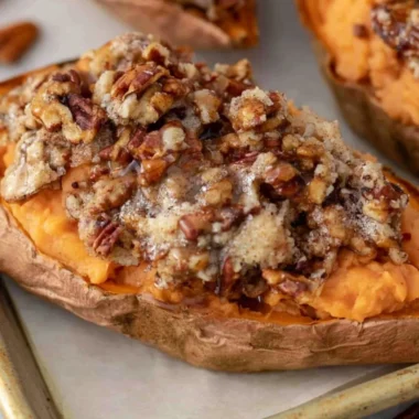 Pecan Pie Twice Baked Sweet Potatoes topped with pecans and caramel glaze