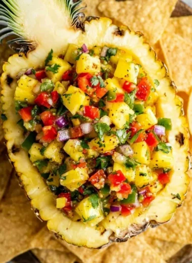 Fresh pineapple salsa served in a bowl with colorful vegetables.