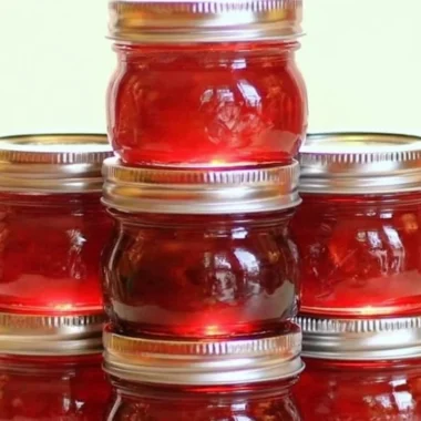 Jar of homemade rhubarb cinnamon jam with fresh rhubarb stalks