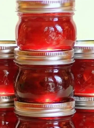 Jar of homemade rhubarb cinnamon jam with fresh rhubarb stalks