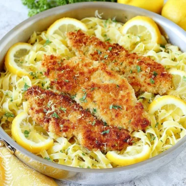 Plate of Romano Chicken served with lemon garlic pasta and fresh herbs