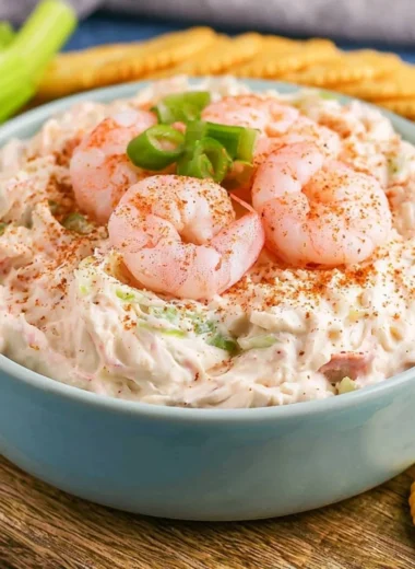 Creamy shrimp dip served in a bowl with fresh herbs and crackers