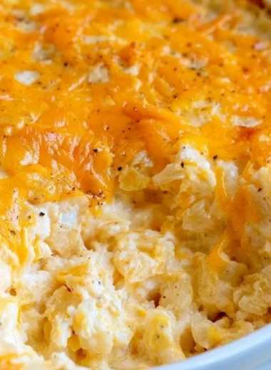 Cheesy hashbrown casserole served in a dish, garnished and ready to enjoy.