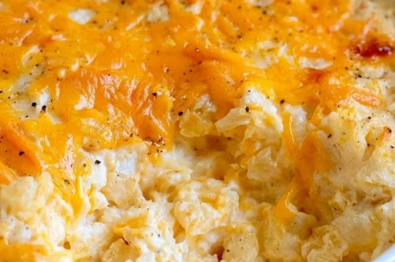 Cheesy hashbrown casserole served in a dish, garnished and ready to enjoy.