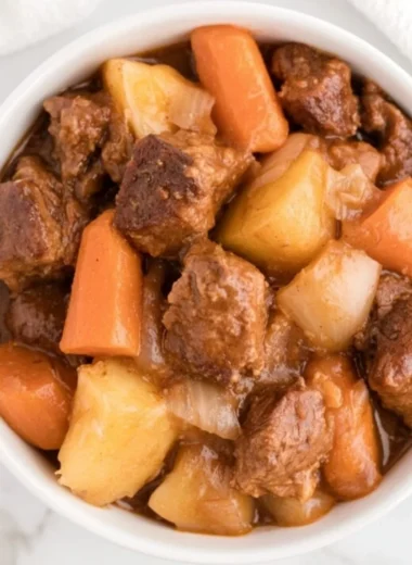 Cozy crockpot beef stew simmering with vegetables and beef.