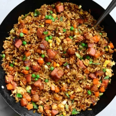 A steaming bowl of cozy delicious Spam Fried Rice garnished with green onions.