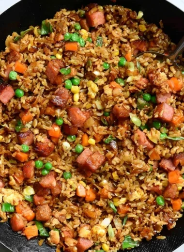 A steaming bowl of cozy delicious Spam Fried Rice garnished with green onions.