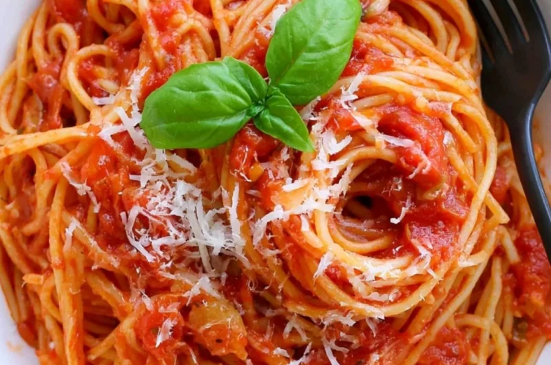 Delicious cozy pasta tomato dish garnished with fresh basil and Parmesan cheese.