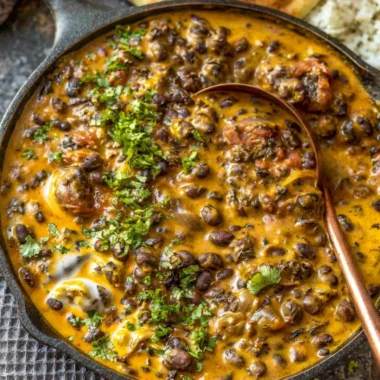 Creamy black bean curry served in a bowl with cilantro garnish
