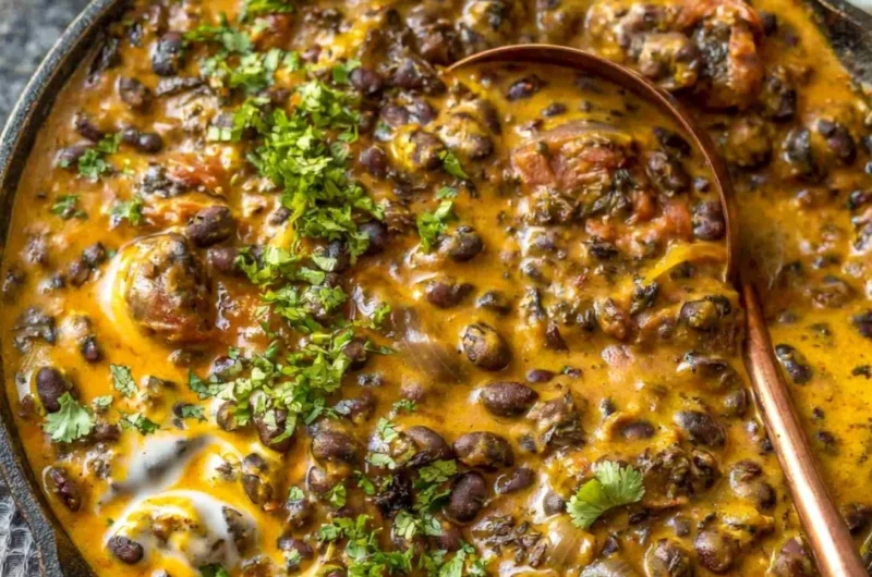 Creamy black bean curry served in a bowl with cilantro garnish