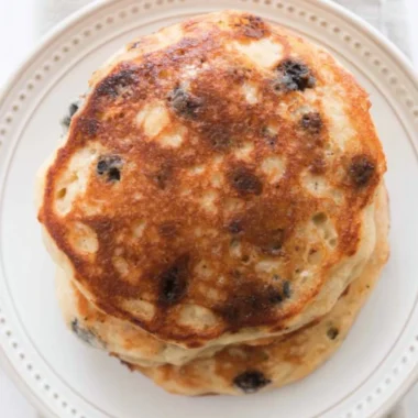 Delicious homemade sourdough pancakes stacked with syrup and berries