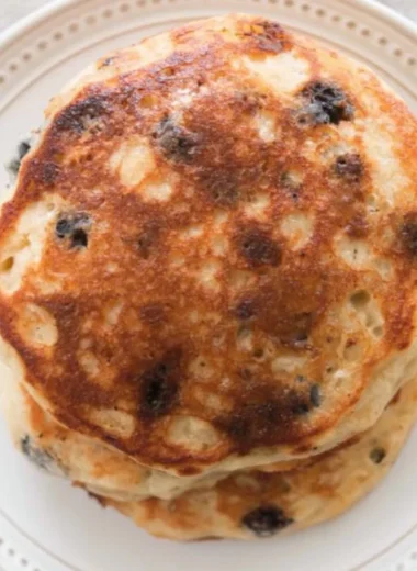 Delicious homemade sourdough pancakes stacked with syrup and berries