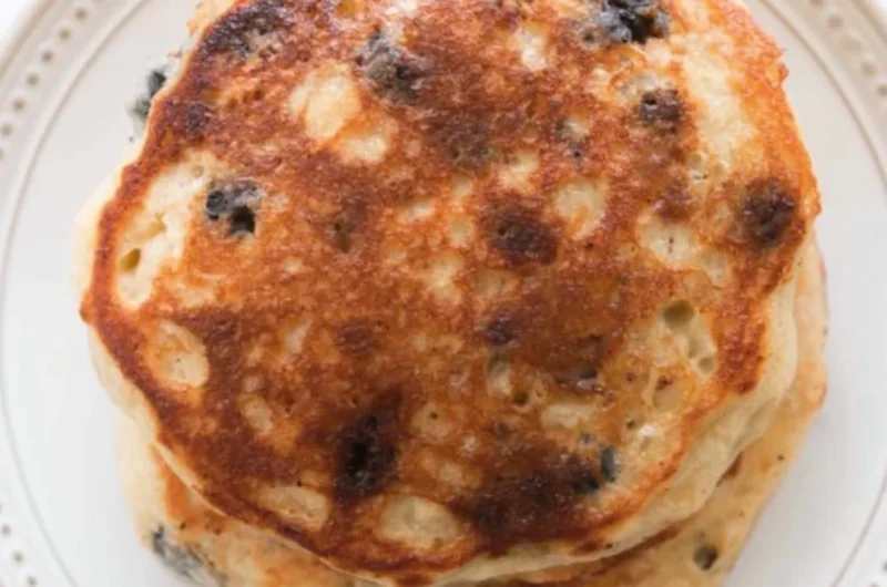 Delicious homemade sourdough pancakes stacked with syrup and berries