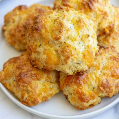 Freshly baked sourdough cheddar biscuits on a wooden table