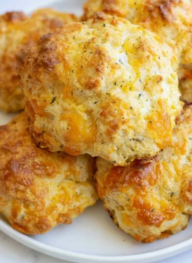 Freshly baked sourdough cheddar biscuits on a wooden table