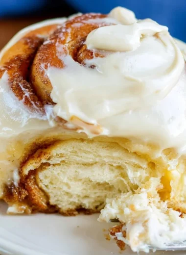 Freshly baked sourdough cinnamon rolls with creamy glaze on a cozy table.