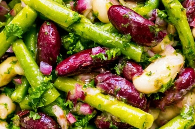 Colorful Three Bean Salad with beans, peppers, and dressing in a bowl