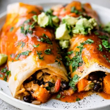 Cozy vegetarian enchiladas filled with fresh vegetables and topped with sauce.