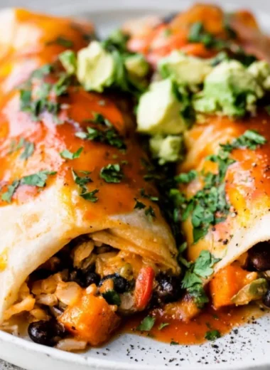 Cozy vegetarian enchiladas filled with fresh vegetables and topped with sauce.