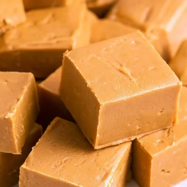 Delicious creamy peanut butter fudge cut into squares on a plate