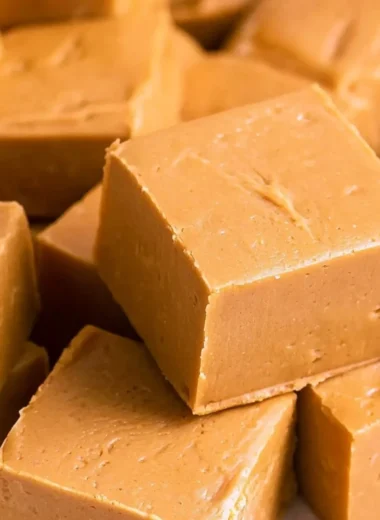 Delicious creamy peanut butter fudge cut into squares on a plate
