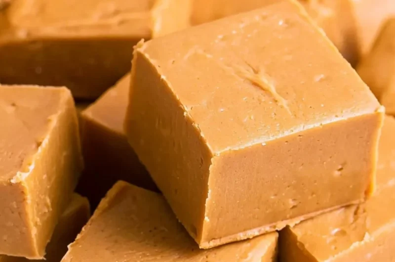 Delicious creamy peanut butter fudge cut into squares on a plate