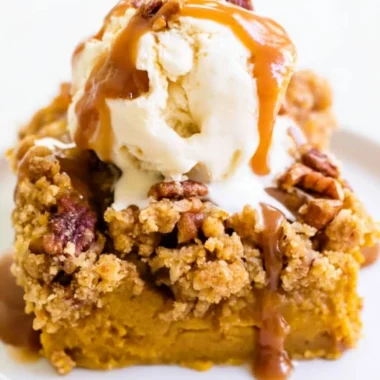 Slice of Pumpkin Pie Crunch Cake with whipped cream and a crunchy topping
