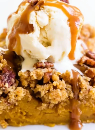 Slice of Pumpkin Pie Crunch Cake with whipped cream and a crunchy topping