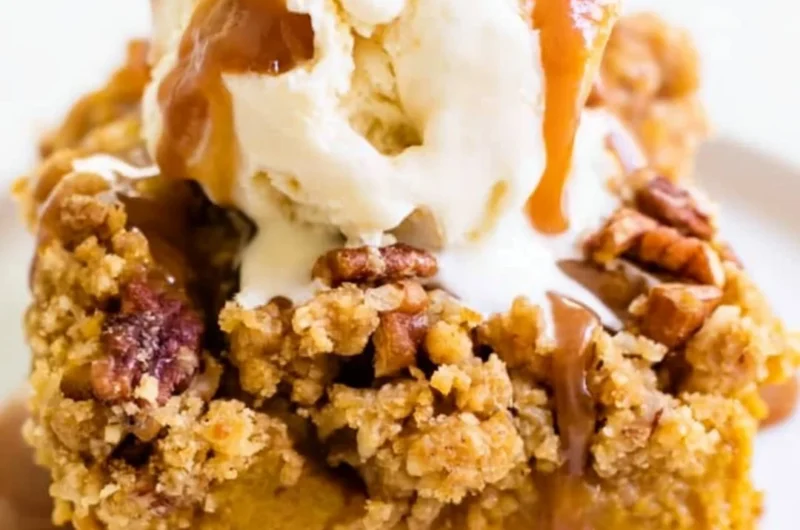 Slice of Pumpkin Pie Crunch Cake with whipped cream and a crunchy topping