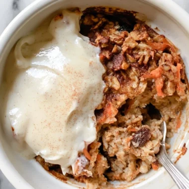 Carrot cake baked oatmeal topped with nuts and cream cheese drizzle