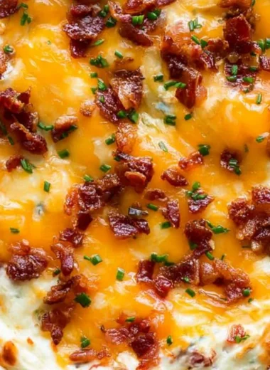 Cream cheese dip with bacon and cheddar served in a bowl with crackers