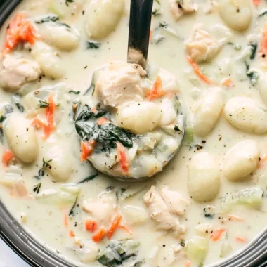Bowl of Olive Garden chicken gnocchi soup with fresh herbs and ingredients