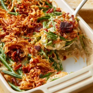 Parmesan Bacon Green Bean Casserole garnished with crispy bacon and cheese.